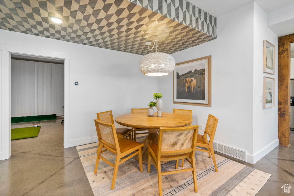 Dining space with concrete floors, visible vents, and baseboards