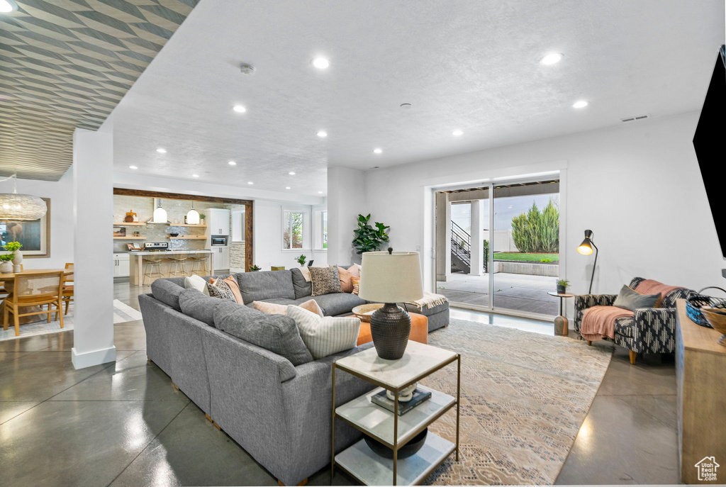 Living area featuring recessed lighting, a healthy amount of sunlight, and finished concrete flooring