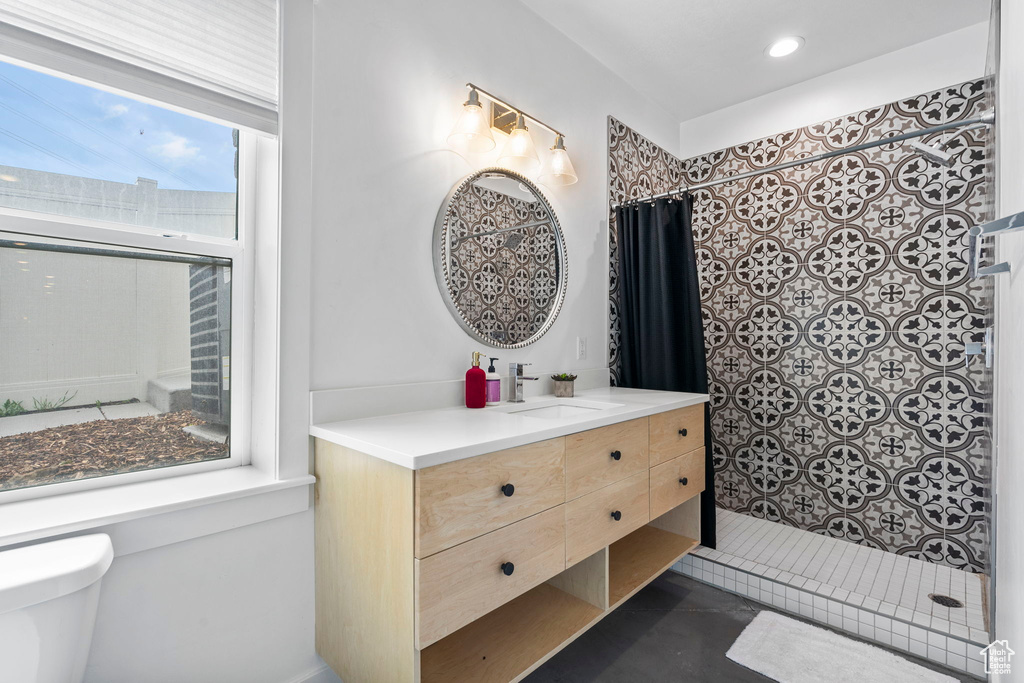 Full bathroom with toilet, a tile shower, recessed lighting, and vanity