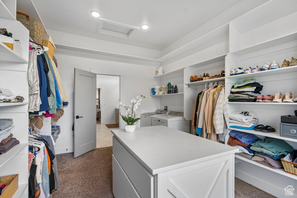 Walk in closet featuring attic access, carpet flooring, and independent washer and dryer