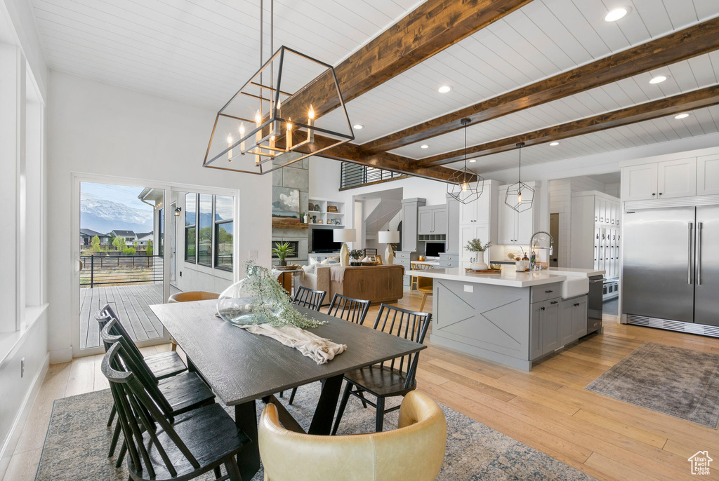 Dining room featuring beam ceiling, recessed lighting, light wood-style flooring, and a notable chandelier