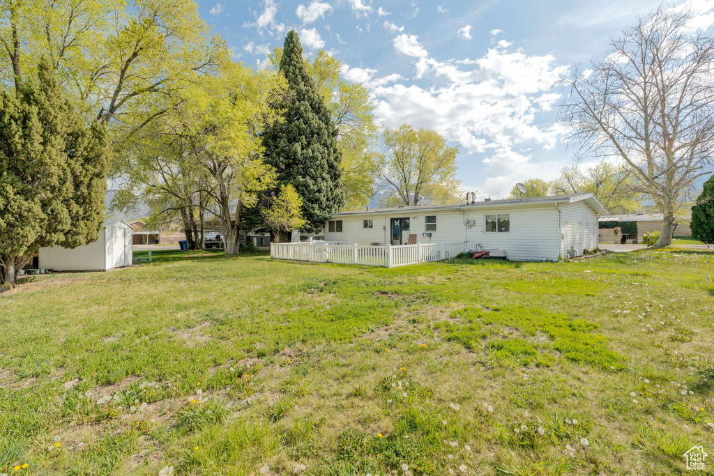 View of yard with fence, a storage unit, and an outdoor structure