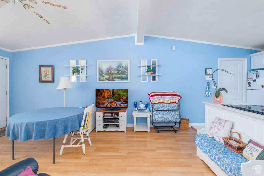 Interior space featuring light wood-style floors, lofted ceiling with beams, crown molding, and baseboards