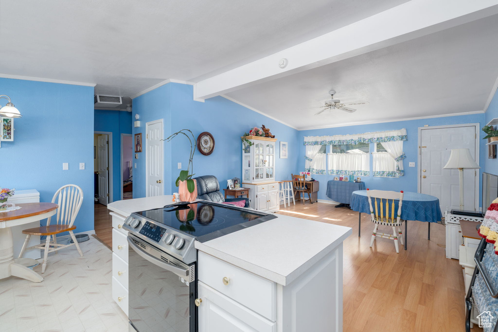 Kitchen with white cabinetry, crown molding, stainless steel electric stove, visible vents, and light wood-style floors