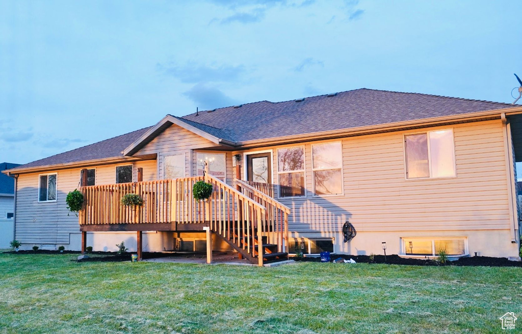 Back of property with stairs, a yard, a wooden deck, and roof with shingles