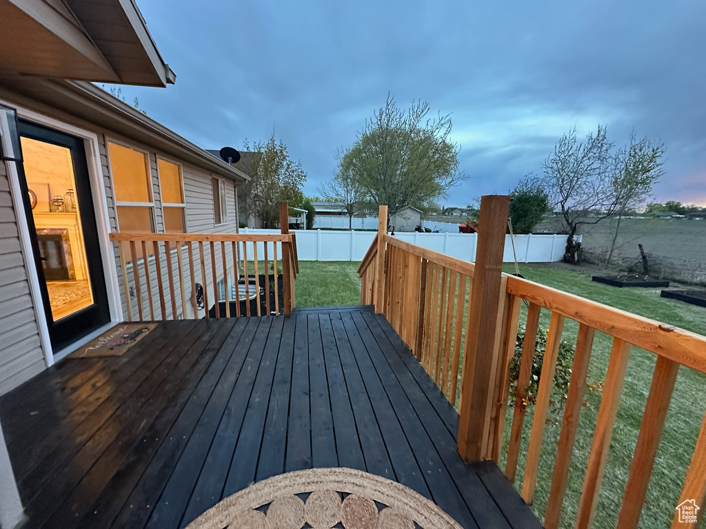 Wooden deck featuring a fenced backyard and a lawn