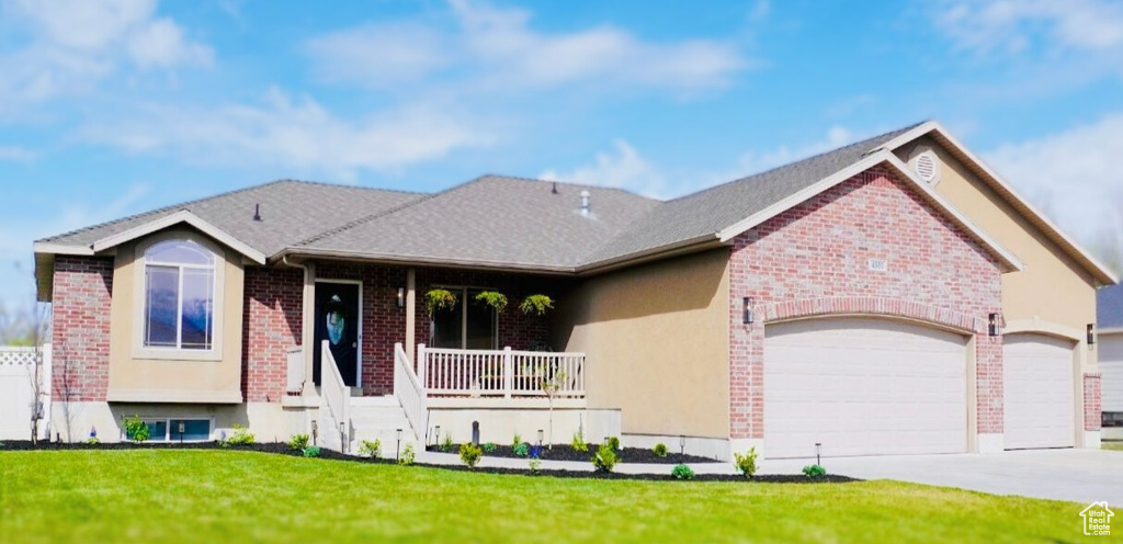 Ranch-style home with brick siding, a porch, a front lawn, and an attached garage