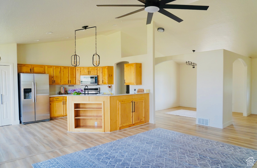 Kitchen with visible vents, high vaulted ceiling, arched walkways, and appliances with stainless steel finishes