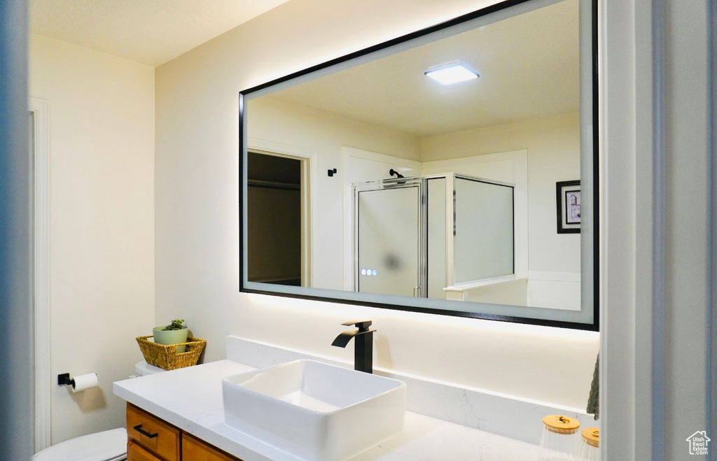 Full bathroom featuring a stall shower, toilet, and vanity