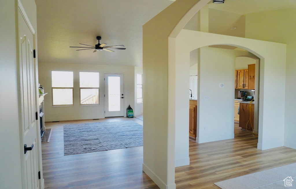 Entrance foyer featuring ceiling fan, light wood-style flooring, lofted ceiling, and baseboards