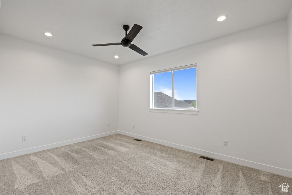 Spare room featuring recessed lighting, light carpet, ceiling fan, baseboards, and visible vents