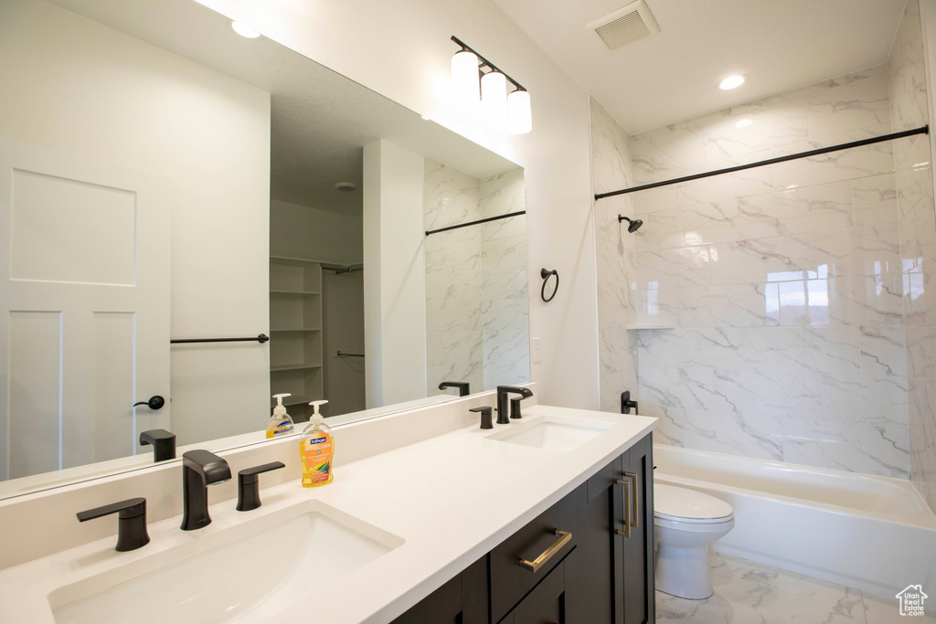 Bathroom featuring visible vents, toilet, marble finish floor, and a sink