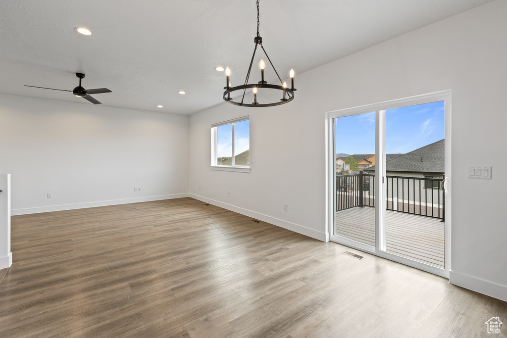 Empty room with recessed lighting, visible vents, wood finished floors, and baseboards