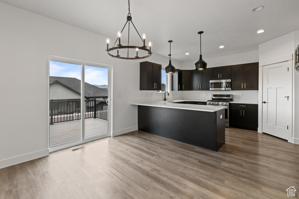Kitchen with recessed lighting, a chandelier, stainless steel appliances, and light countertops