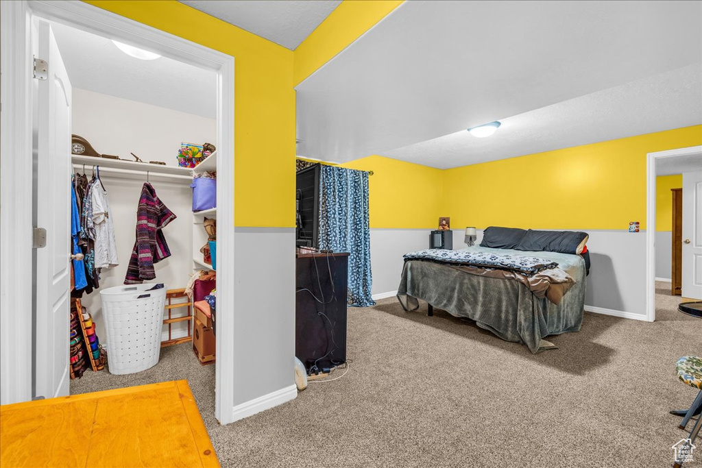 Carpeted bedroom featuring baseboards and a closet