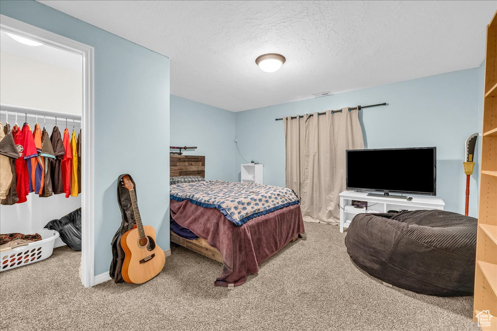 Bedroom featuring a textured ceiling, baseboards, and carpet floors