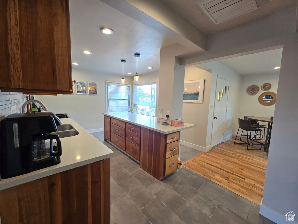 Kitchen featuring decorative light fixtures, light countertops, recessed lighting, and baseboards