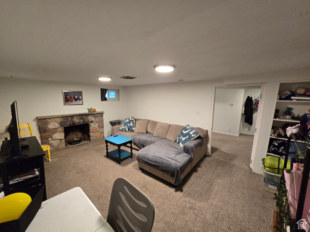 Living area featuring visible vents, a fireplace, and carpet flooring
