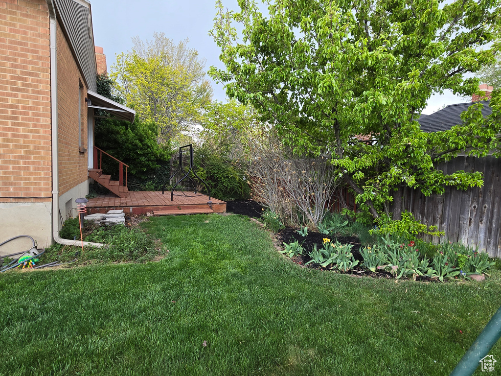 View of yard with fence and a wooden deck