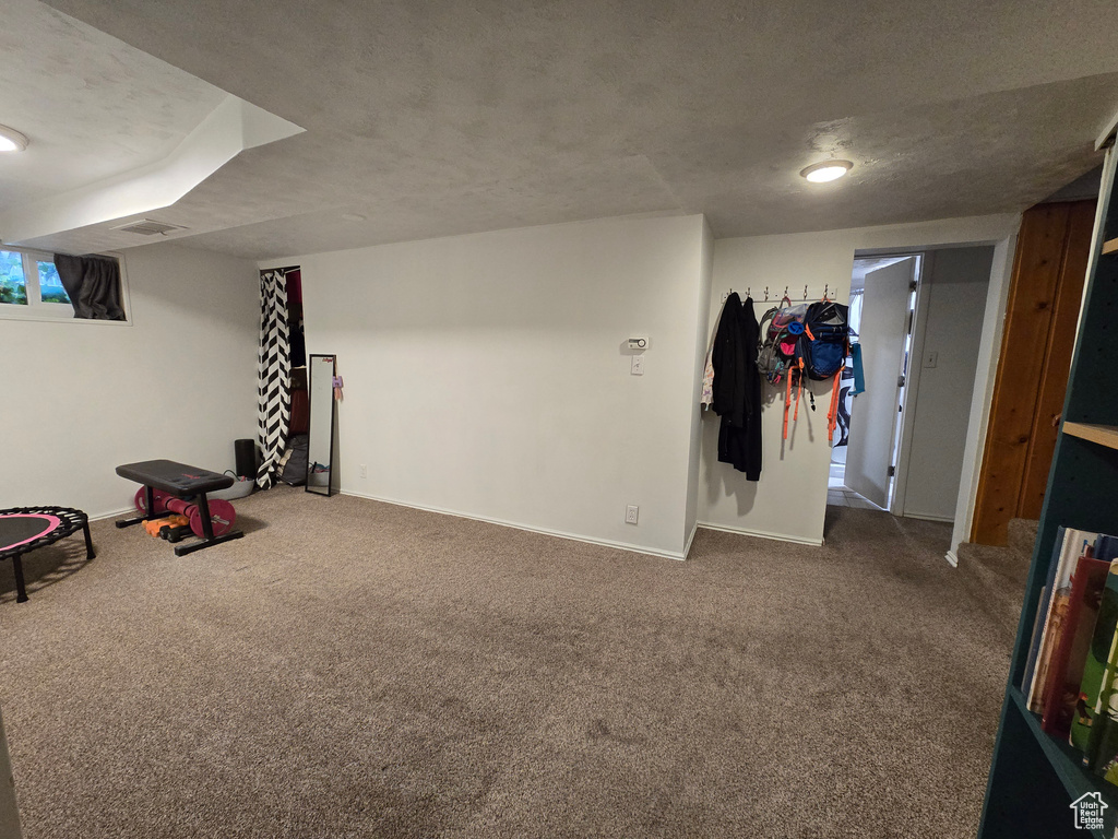 Finished basement featuring baseboards, visible vents, and carpet floors