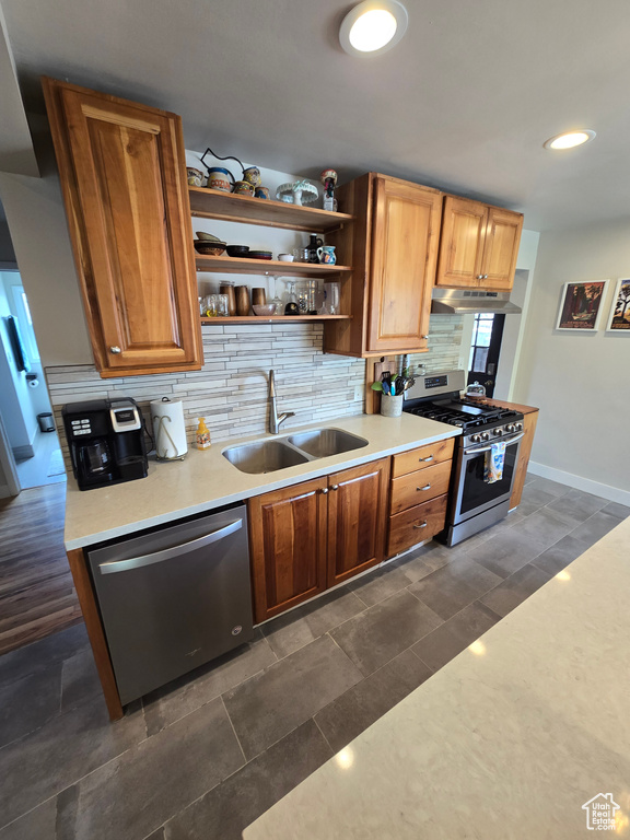 Kitchen with open shelves, under cabinet range hood, appliances with stainless steel finishes, backsplash, and a sink
