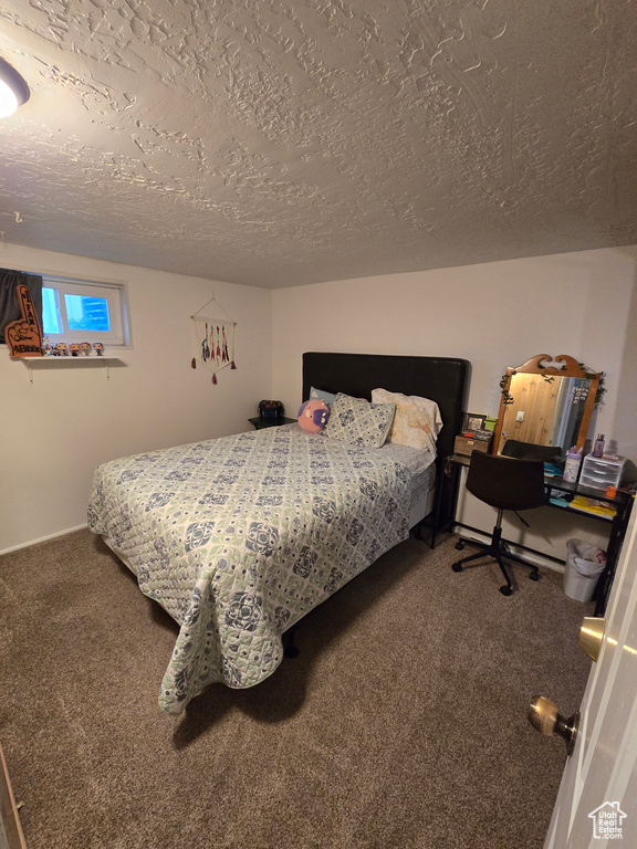 Carpeted bedroom featuring a textured ceiling