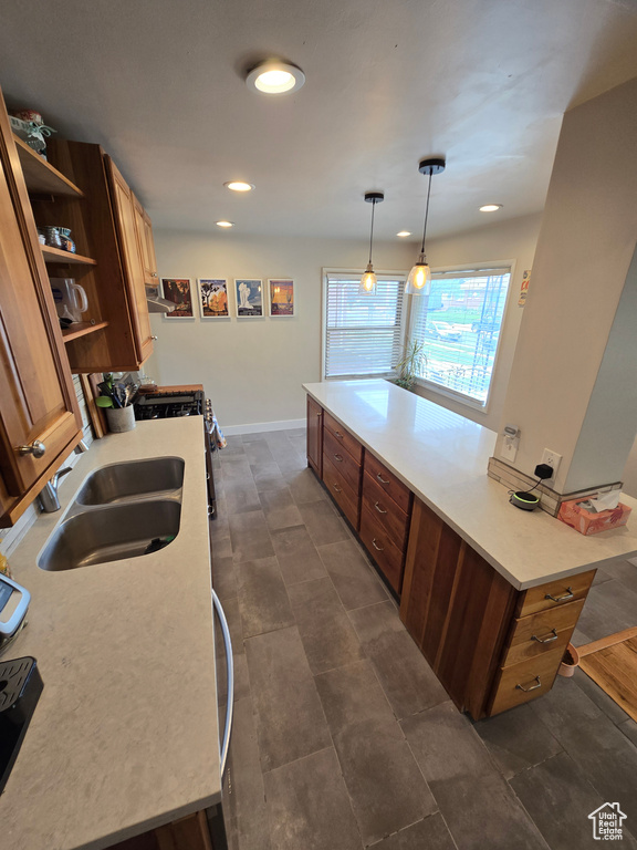 Kitchen with recessed lighting, open shelves, light countertops, range hood, and a sink
