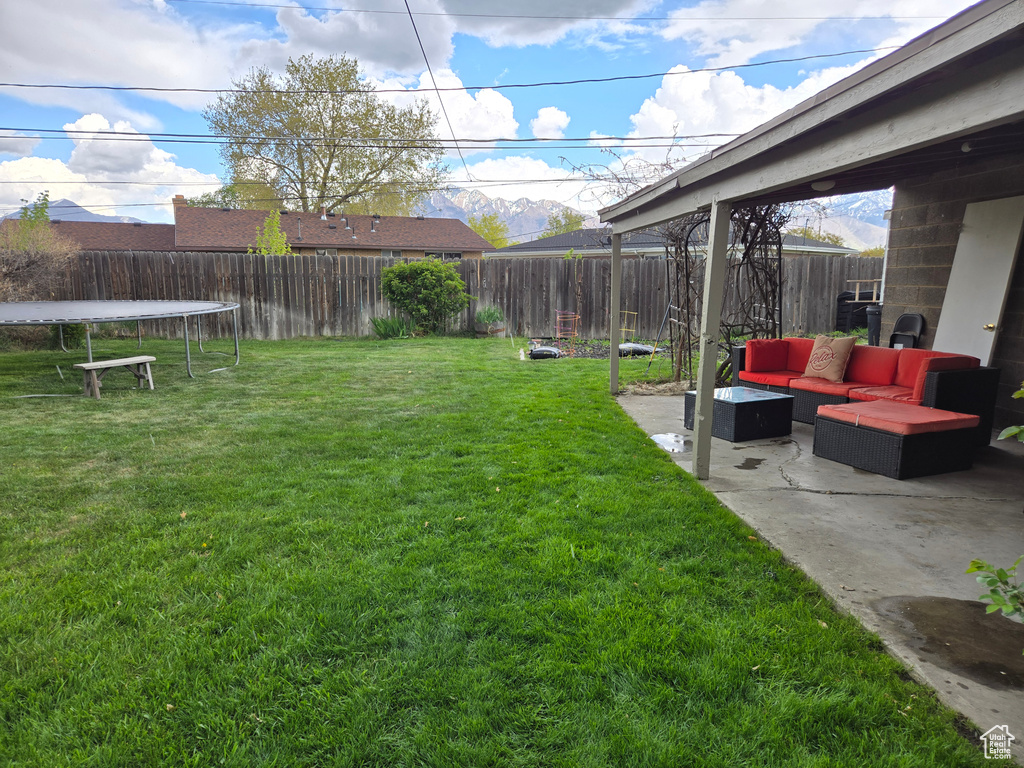 View of yard with outdoor lounge area, a trampoline, a patio, and a fenced backyard