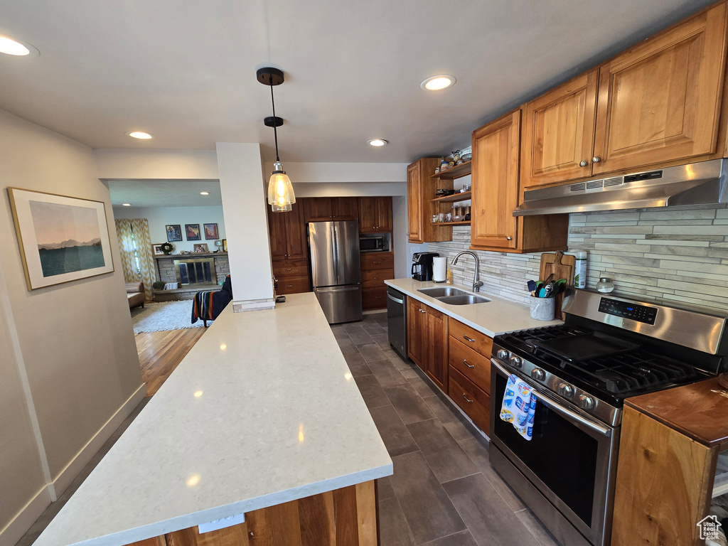 Kitchen featuring decorative backsplash, open shelves, a sink, stainless steel appliances, and under cabinet range hood