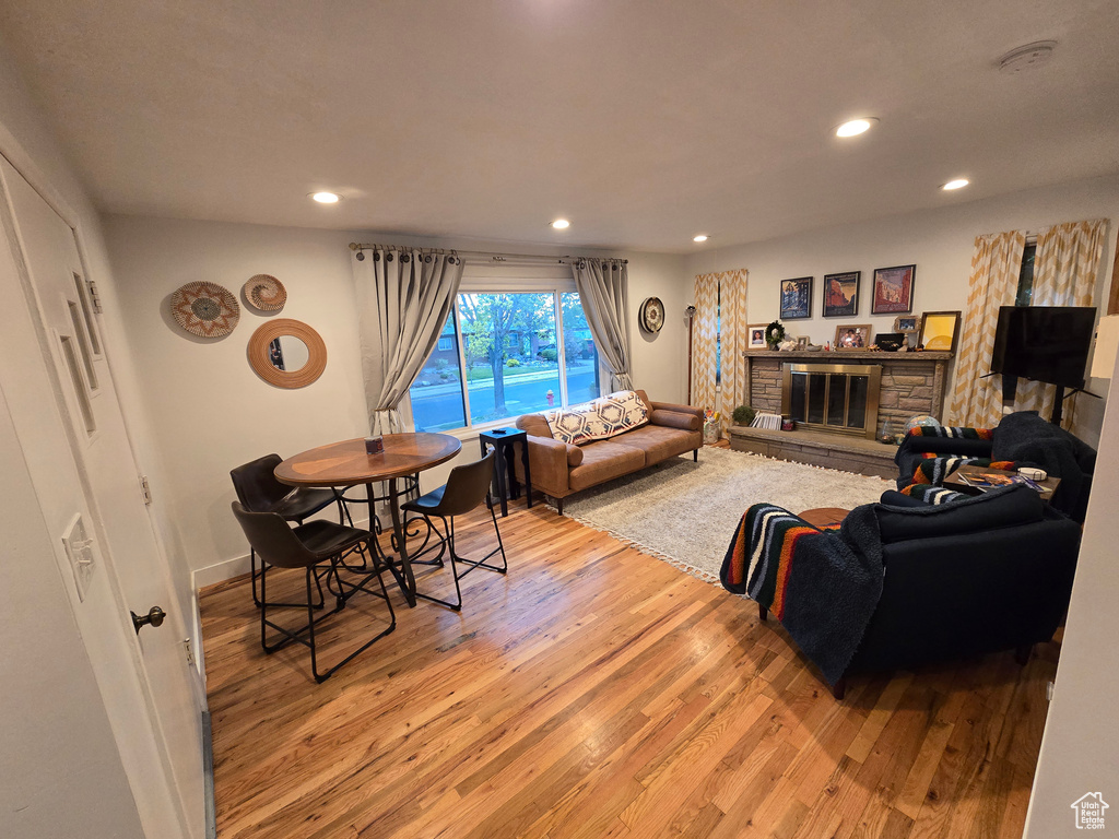 Living area featuring baseboards, recessed lighting, wood finished floors, and a fireplace
