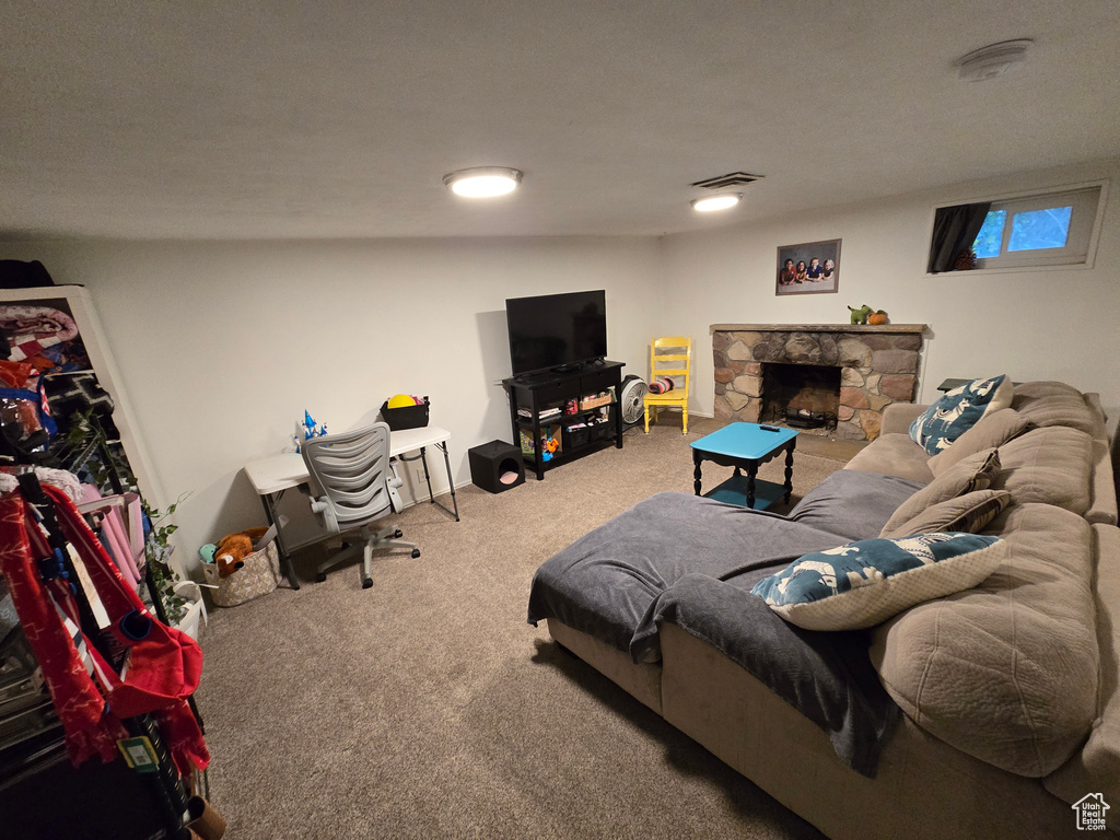 Carpeted living area featuring a fireplace and visible vents