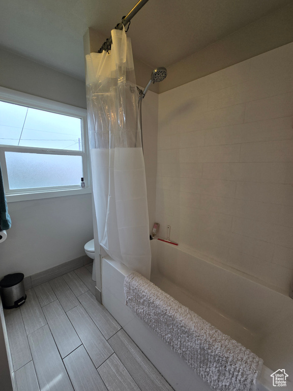 Full bath featuring shower / tub combo and toilet