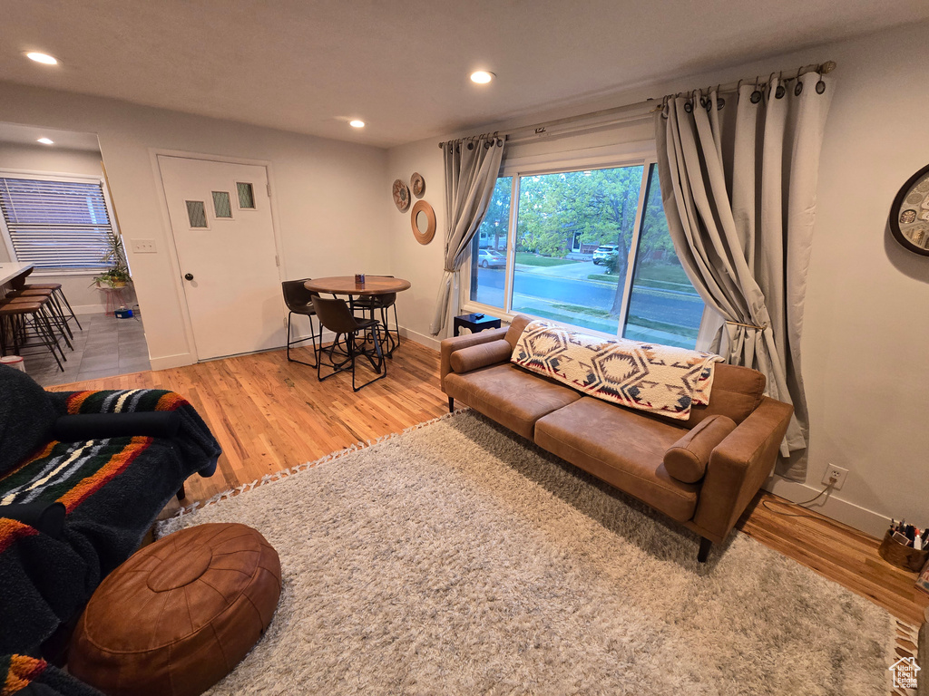 Living room with recessed lighting, light wood finished floors, and baseboards