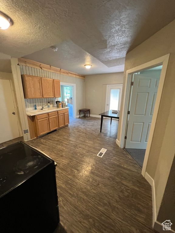 Kitchen featuring dark wood-style floors, black / electric stove, visible vents, baseboards, and a textured ceiling