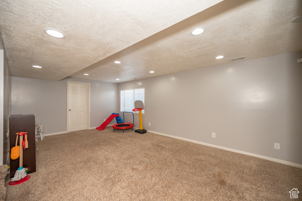 Playroom featuring a textured ceiling, recessed lighting, carpet, and baseboards