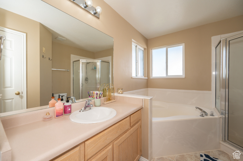 Full bath with a stall shower, a garden tub, tile patterned flooring, and vanity