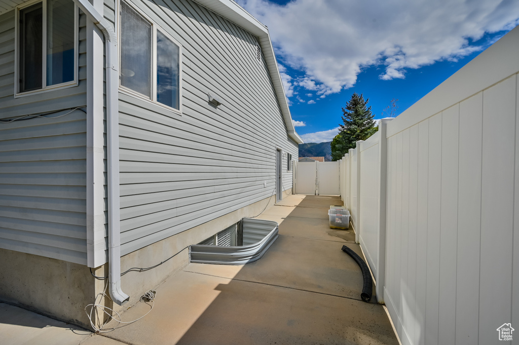 View of property exterior with fence and a patio area