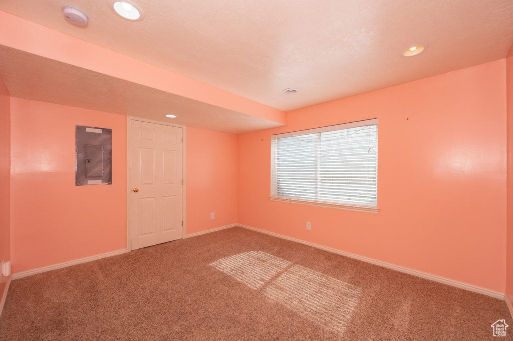 Carpeted spare room featuring baseboards, recessed lighting, and electric panel