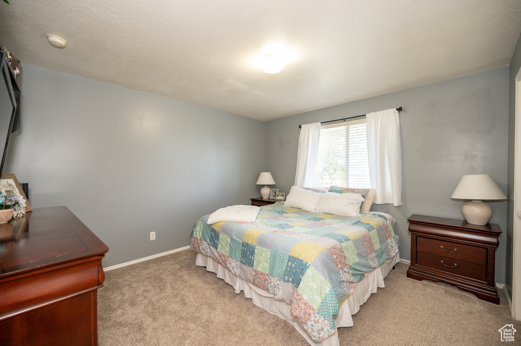 Bedroom with baseboards and light colored carpet
