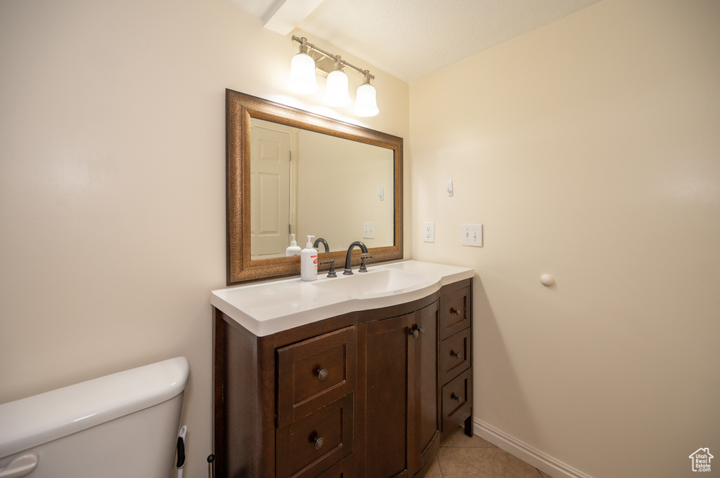 Bathroom with toilet, tile patterned flooring, vanity, and baseboards