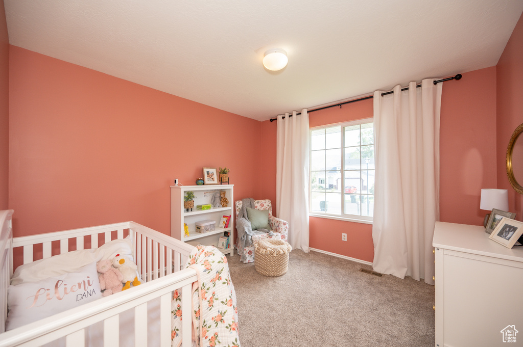 Carpeted bedroom with a crib