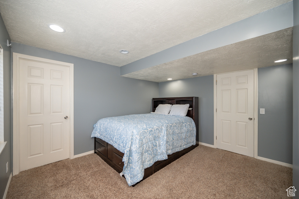 Carpeted bedroom with baseboards, recessed lighting, and a textured ceiling