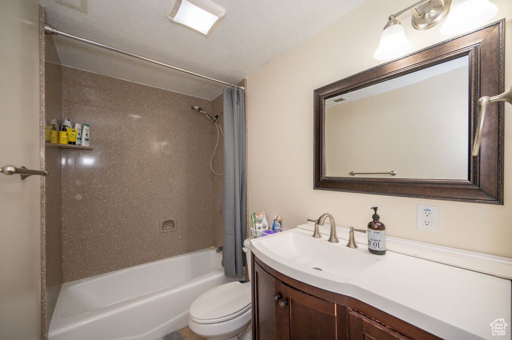 Full bath with toilet, shower / bathtub combination with curtain, and vanity