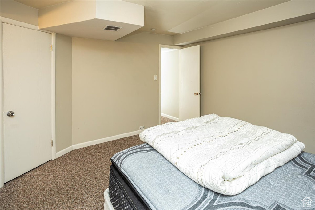 Carpeted bedroom with visible vents and baseboards