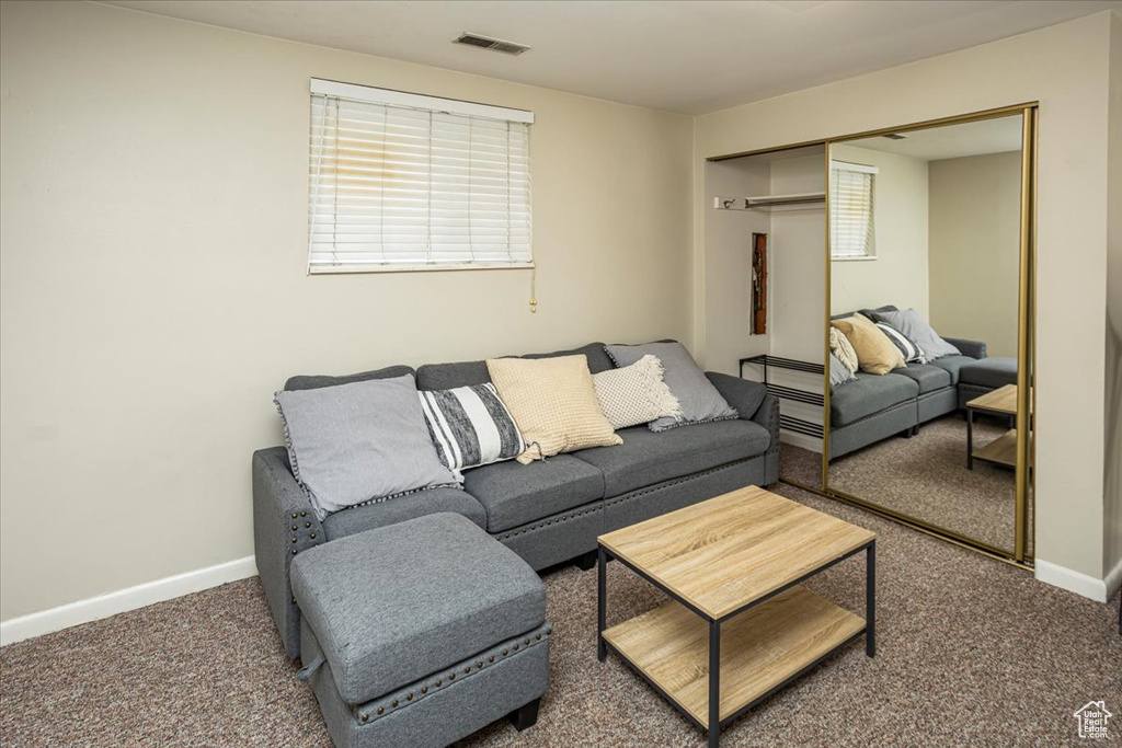 Living room featuring baseboards, visible vents, and carpet flooring