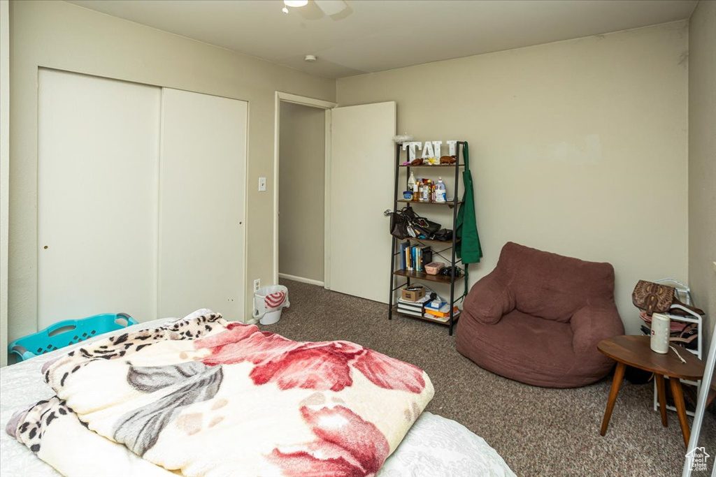 Carpeted bedroom featuring ceiling fan and a closet