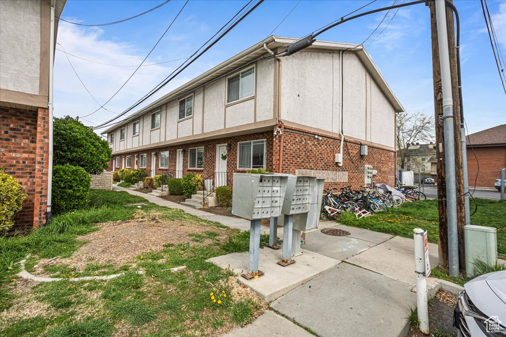 Exterior space featuring stucco siding, brick siding, and mail area