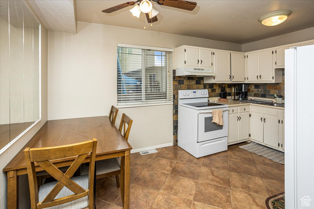 Kitchen featuring white cabinetry, ceiling fan, under cabinet range hood, white appliances, and backsplash