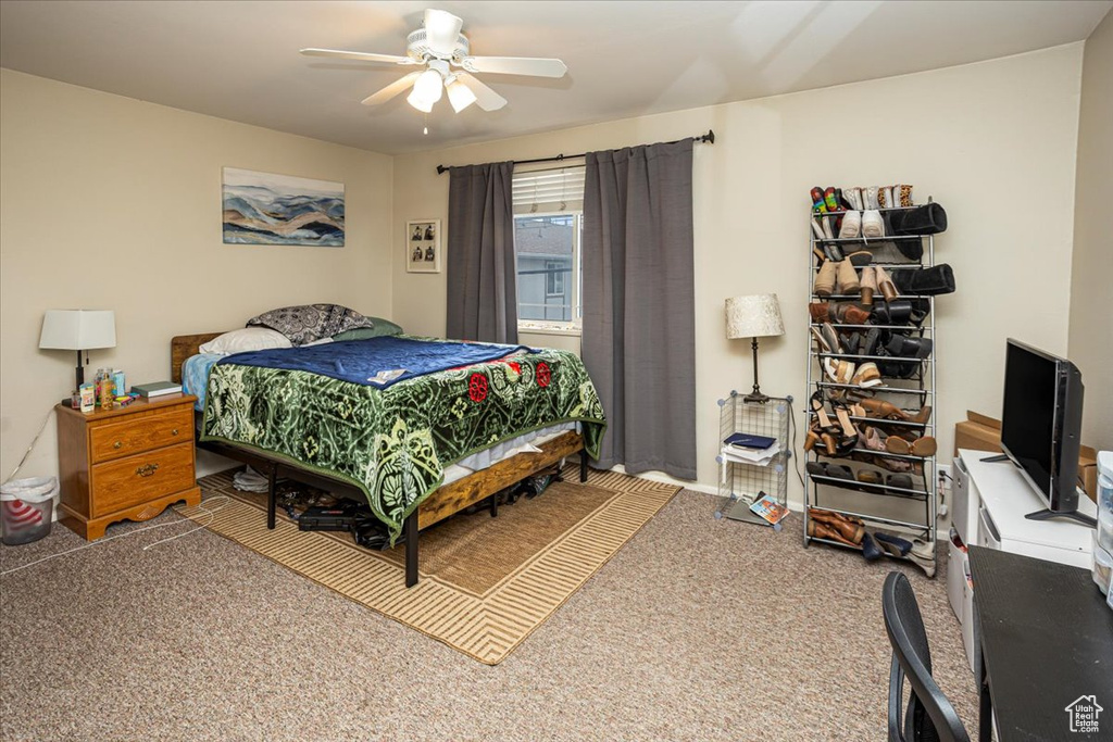 Carpeted bedroom featuring ceiling fan