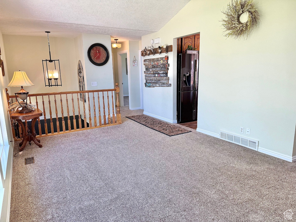 Unfurnished room with carpet, a textured ceiling, and baseboards